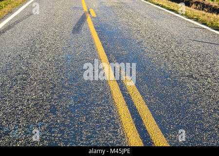 Road close up with passing and no passing zones.  Skid marks are on the pavement. Stock Photo