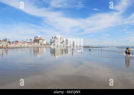 View of Coronado Beach on a sunny spring day, with the water reflecting a big sky Stock Photo