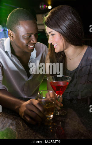Couple looking at each other and smiling while having drinks Stock Photo