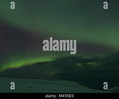 Aurora borealis over snow covered landscape at night, Finnmark, Norway Stock Photo