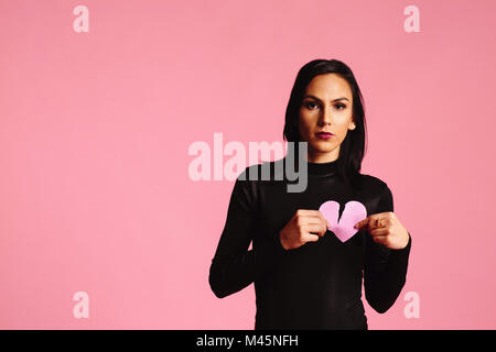 woman in black holding a broken heart Stock Photo