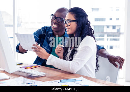 Cheerful businessman discussing with businesswoman over documents Stock Photo