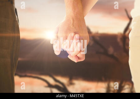 Composite image of happy senior couple holding hands Stock Photo