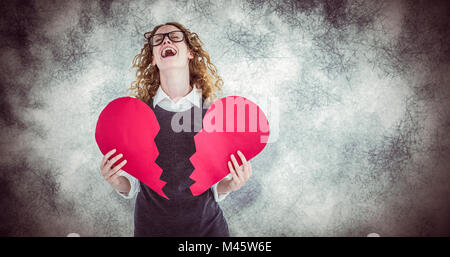 Composite image of geeky hipster holding a broken heart card Stock Photo