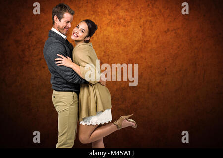 Composite image of full length of romantic couple hugging Stock Photo