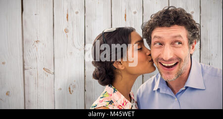 Composite image of pretty woman kissing man on cheek Stock Photo