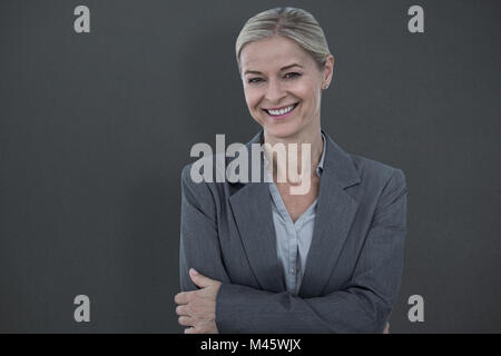 Composite image of portrait of beautiful businesswoman standing arms crossed Stock Photo