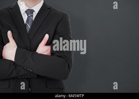 Composite image of mid section of businessman with arms crossed Stock Photo