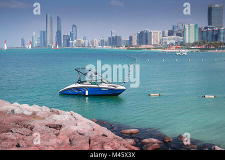 Small Boat at Corniche Abu Dhbai with city buildings in background Stock Photo