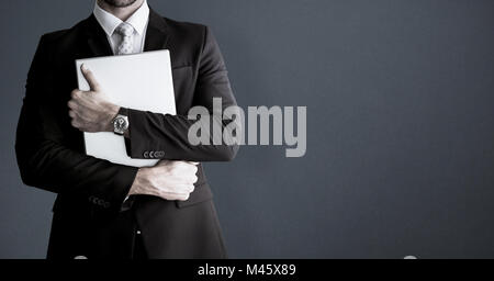 Composite image of mid section of businessman holding computer Stock Photo