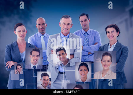 Composite image of business team working happily together on laptop Stock Photo