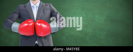 Composite image of businessman with boxing gloves Stock Photo