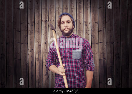 Composite image of portrait of hipster holding axe Stock Photo