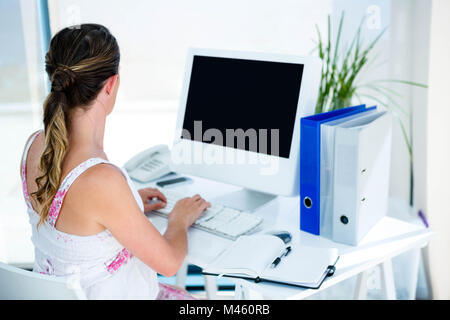 pregnant business woman typing on her computer Stock Photo