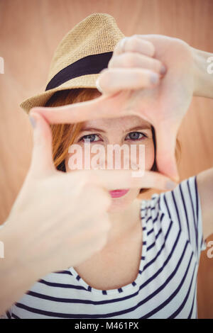 blue eyed hipster woman looking through her hand Stock Photo