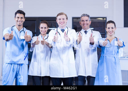 Medical team putting their thumbs up and smiling Stock Photo - Alamy