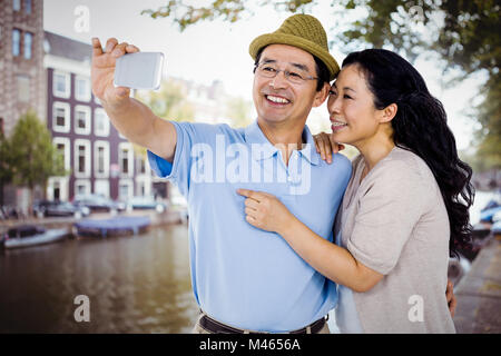 Composite image of man and woman taking a picture