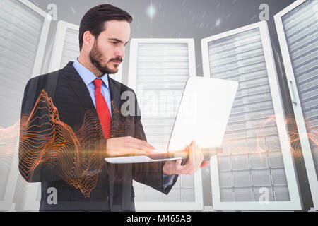 Composite image of focused businessman using his laptop Stock Photo