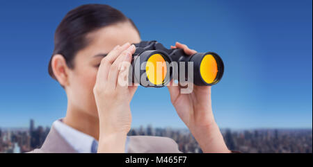 Composite image of brunette businesswoman looking through binoculars Stock Photo