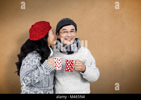 Composite image of older asian couple having hot drinks Stock Photo