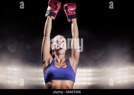 Composite image of winning fighter with arms raised Stock Photo