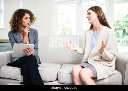 Young woman explaining problems to psychologist Stock Photo