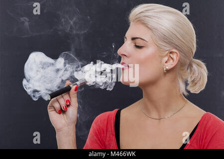 Stylish blond woman smoking an e-cigarette Stock Photo