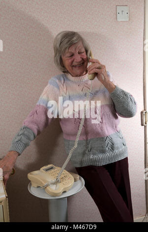 Elderly woman talking to friend by telephone Stock Photo
