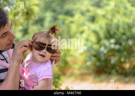 Amazing little girl is playing with sunglasses with her father Stock Photo