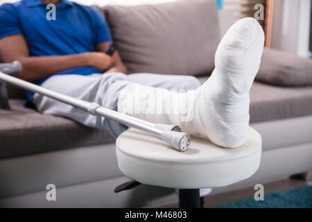 Close-up Of A Man's Broken Leg And Crutches Stock Photo