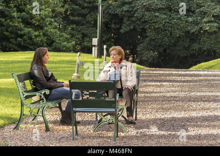 Grandmother and Granddaughter Chatting at Garden Stock Photo