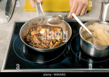 Cooking meat and vegetables on pan by chef hands. Steps homemade recipe. on the side dish polenta Stock Photo
