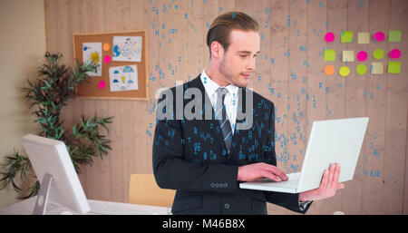 Composite image of businessman in suit typing on laptop Stock Photo