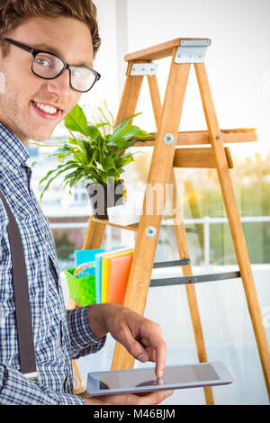 Composite image of geeky businessman using his tablet pc Stock Photo