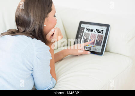 Composite image of woman touching her digital tablet Stock Photo