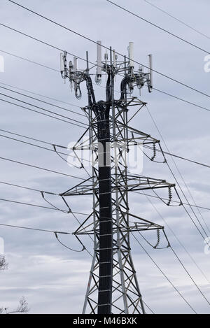 communication antennas on electrical power transmission line towers Stock Photo