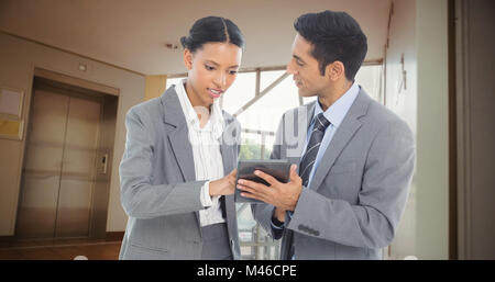 Composite image of business people discussing over digital tablet Stock Photo