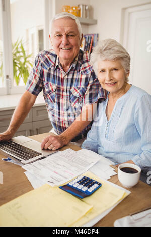 Portrait of senior couple checking their bills Stock Photo