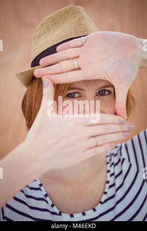 blue eyed hipster woman looking through her hand Stock Photo