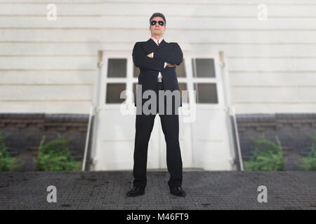 https://l450v.alamy.com/450v/m46ft9/portrait-of-a-serious-male-security-guard-standing-at-entrance-of-m46ft9.jpg