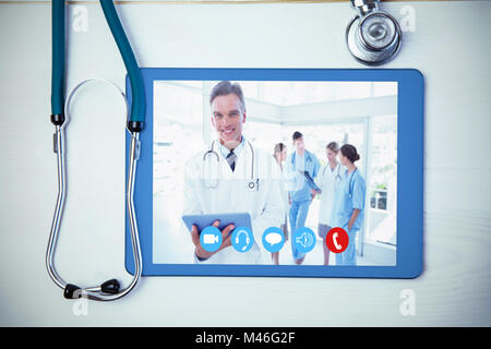 Composite image of smiling doctor holding digital tablet Stock Photo
