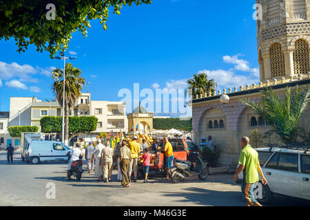 Street scene with trading of melons in casual market. Cityscape near mosque in old town. Nabeul, Tunisia Stock Photo