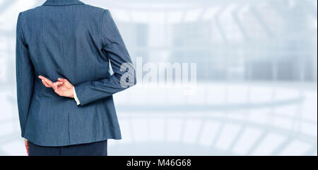 Composite image of businesswoman with fingers crossed behind her back Stock Photo