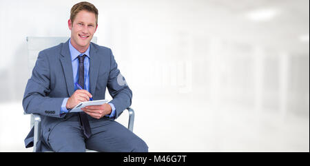 Composite image of businessman writing down on a notebook Stock Photo