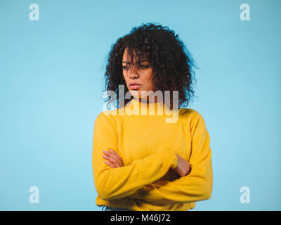 Angry annoyed young housewife keeping arms crossed and staring at camera with sceptical and distrustful look, feeling mad at someone. Human facial exp Stock Photo