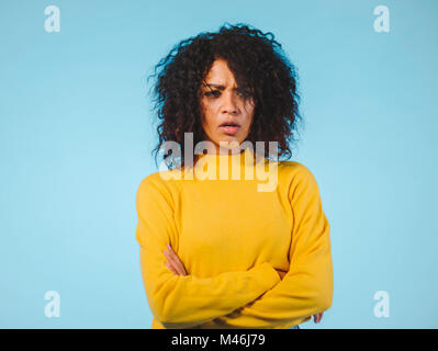 Angry annoyed young housewife keeping arms crossed and staring at camera with sceptical and distrustful look, feeling mad at someone. Human facial exp Stock Photo