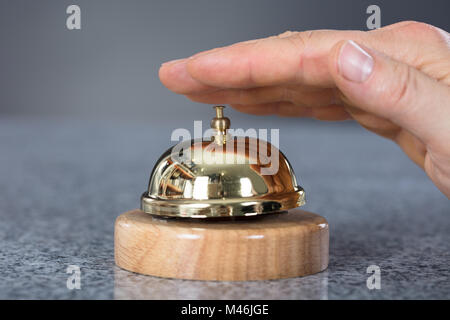 Close-up Of A Person Hand Ringing Hotel Service Bell Stock Photo