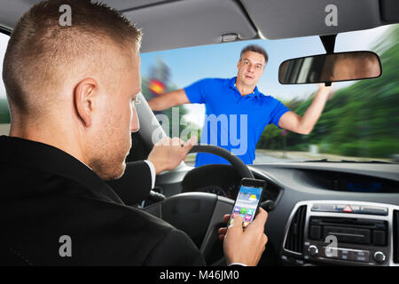 An Irresponsible Driver Is About To Run Over A Pedestrian While Using Mobilephone Stock Photo