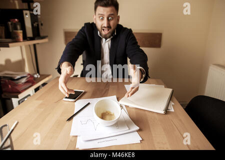 Coffee in white cup spilling on the table in the morning working day at office table Stock Photo