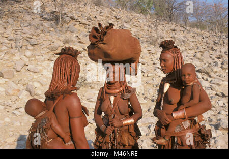 Namibia. Kaokoveld, near Opuwo. Himba tribe. Women, mothers and baby. Stock Photo